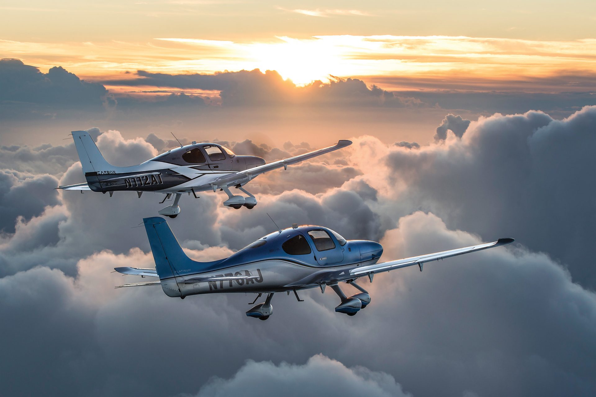 Two Cessna 22Ts flying above billowing clouds at sunset